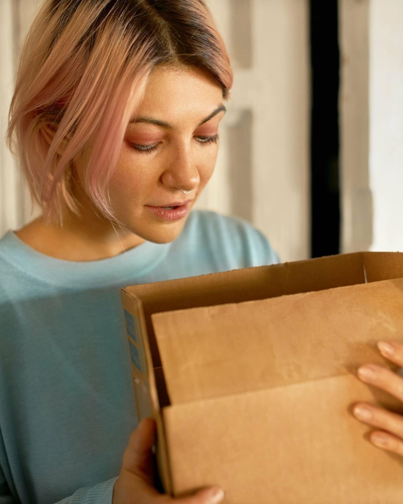 Ein Paket mit leeren Tintenpatronen in den Händen einer Frau.