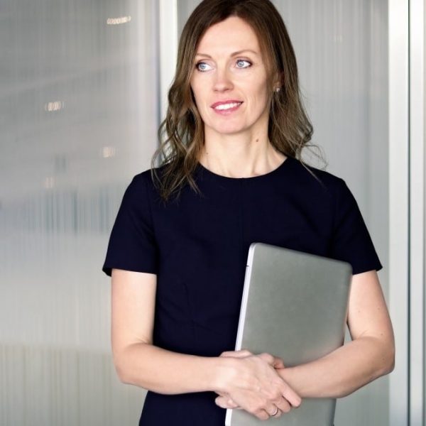 portrait-of-young-attractive-smiling-modern-business-woman-in-dark-blue-dress-holding-laptop-looking_t20_Nx8wAp